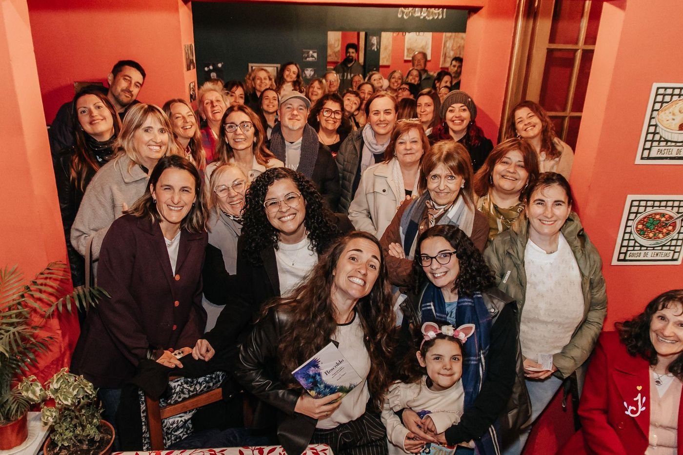Paula Florez con Rescoldo en la mano, rodeada de lectoras y amigas en la presentación del libro